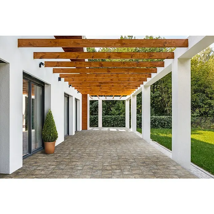 Terrassenplatte Latina - 48 x 24 x 3 cm, Muschelkalk, Beton - Außenaufnahme einer gepflasterten Terrasse mit Pergola und Blick in den Garten. Holz- und Betonstrukturen dominieren dieses Bild.