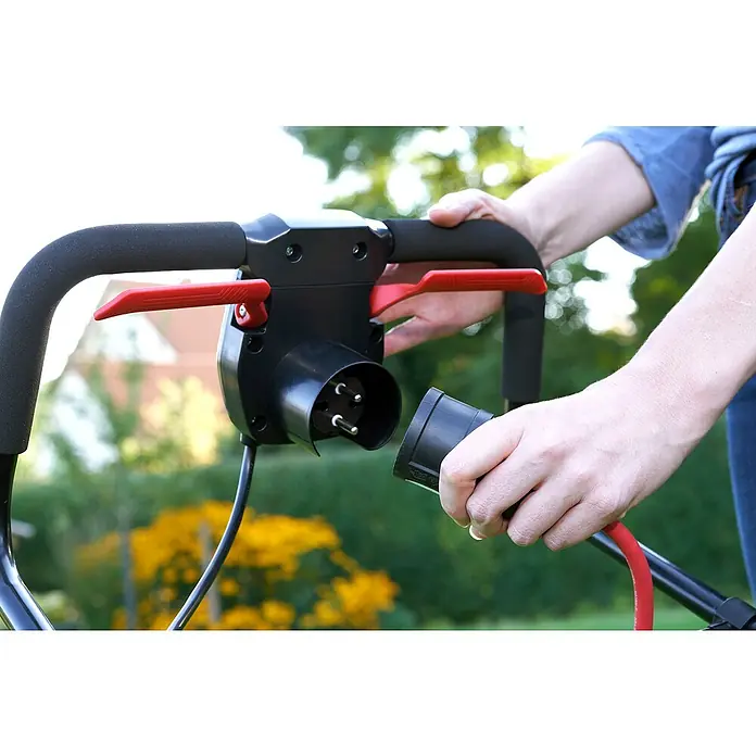 AL-KO Comfort Elektro-Rasenmäher - 1.600 W, Schnittbreite: 38 cm - Eine Person, die das Stromkabel eines Rasenmähers an eine Steckdose anschließt, um den Rasenmäher mit Strom zu versorgen und den Rasen zu mähen.