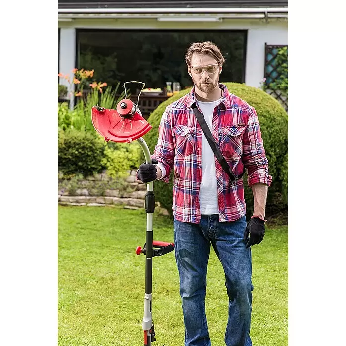 AL-KO 36V Rasentrimmeraufsatz GTA 430 - Passend für: Multitool MT 40 Li/MT 36 Li - Roter und grauer Rasentrimmer, von einem Mann im Garten gehalten, einsatzbereit.