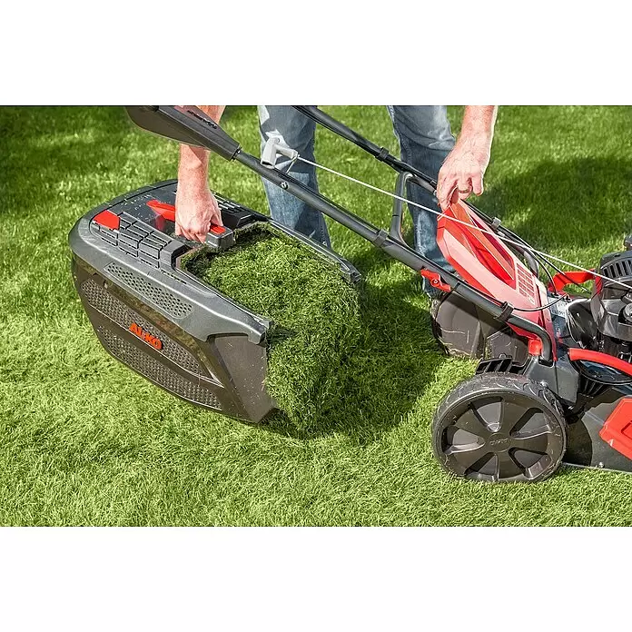AL-KO Premium Benzin-Rasenmäher 521 SP-A - 2,6 kW, 166 cm³, Schnittbreite: 51 cm - Person entleert einen grauen AL-KO Rasenmäher-Grasfangkorb voller Schnittgut.