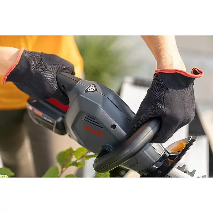 AL-KO Bosch Home & Garden Compatible Akku-Heckenschere HT 1845 - 18 V, Li-Ionen, 1 Akku, Schnittlänge: 45 cm - Hände in schwarzen Schutzhandschuhen bedienen eine graue AL-KO Akku-Heckenschere zum Schneiden von Pflanzen.
