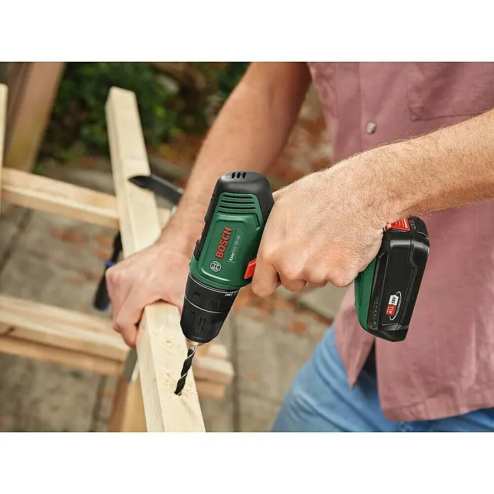 Bosch Power for All 18V Taladro atornillador de batería EasyDrill 18V-40 - 18 V, 1 batería, 2 Ah, 40 Nm - El taladro atornillador inalámbrico Bosch EasyDrill 18V-40 en acción, perforando un agujero en un trozo de madera.