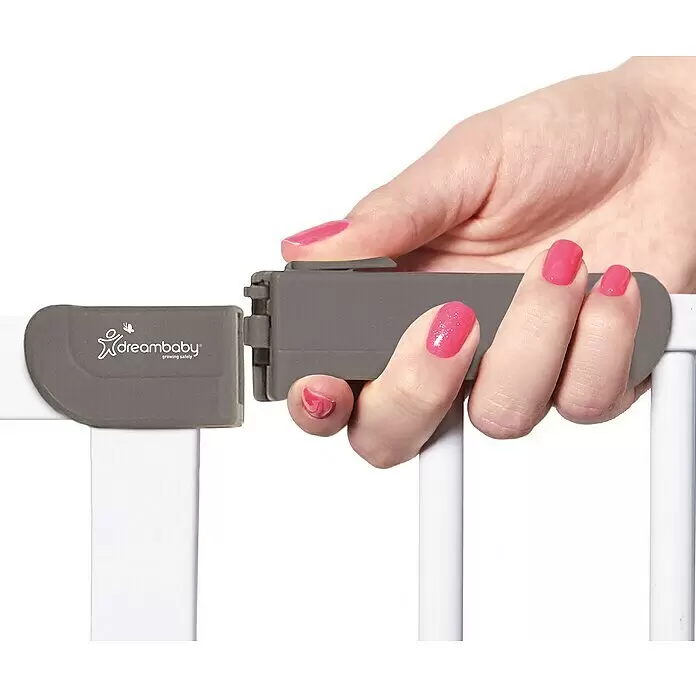 Dreambaby Türschutzgitter Ava - Höhe: 76 cm, Weiß - Hand betätigt grauen Dreambaby Kindersicherheitsverschluss an weißem Gitter.