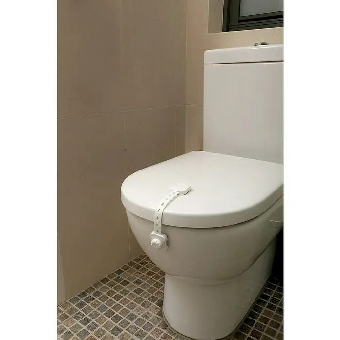 Dreambaby Multifunktionsverschluss Twist n Lock - Kleben, 2 Stk. - Ein weißes WC mit einer Kindersicherung am Deckel, um unbefugten Zugriff zu verhindern und die Sicherheit im Badezimmer zu gewährleisten.