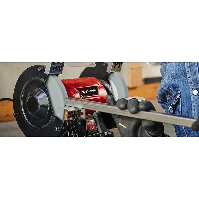 Einhell Schleifscheibe - Durchmesser: 150 mm, Körnung: 60, Stärke: 16 mm, Durchmesser Bohrung: 32 mm - Das Bild zeigt eine Einhell Doppelschleifmaschine im Einsatz, bei der ein Metallstück bearbeitet wird und Funken sprühen.