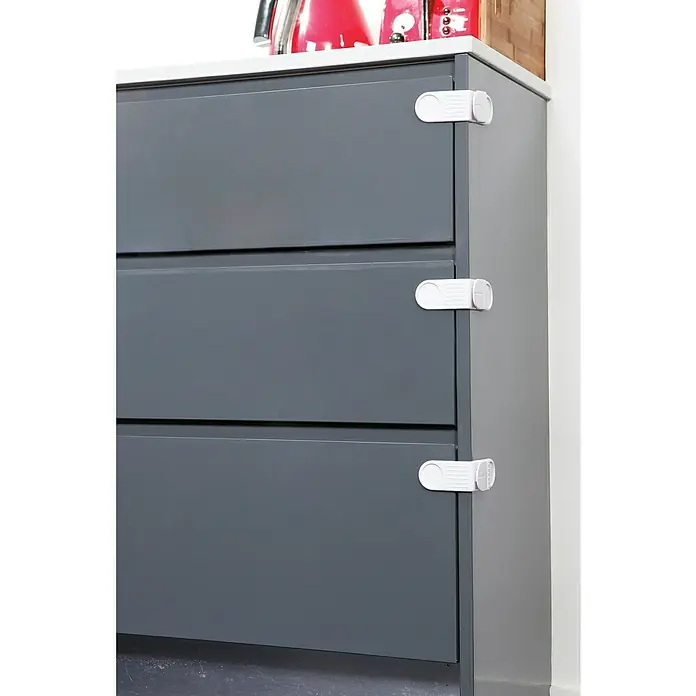 Dreambaby Kindersicherheits-Set 35 -tlg. - Weiß - Bild von einem grauen Schrank mit drei Schubladen, die mit weißen Kindersicherungen gesichert sind.