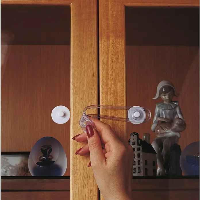 Dreambaby Kindersicherheits-Set 35 -tlg. - Weiß - Ein Schrank ist mit einem transparenten Schrankschloss gesichert, das an den Türen befestigt ist und so den Inhalt schützt.