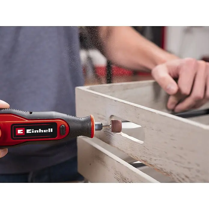 Einhell Akku-Multifunktionswerkzeug - 7,2 V, 1 Akku, 1.500 mAh - Nahaufnahme eines roten Einhell Multifunktionswerkzeugs beim Schleifen eines Holzprojekts, das die Präzision und Vielseitigkeit des Werkzeugs hervorhebt.