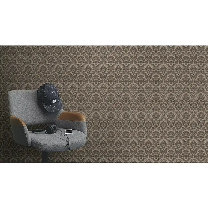 Rasch Trianon XIII Vliestapete BarockTaupe, Ornament, 10,05 x 0,53 m - Eine graue Drehstuhl mit einer Mütze, Kopfhörern und einem Player vor einer verzierten Wand.
