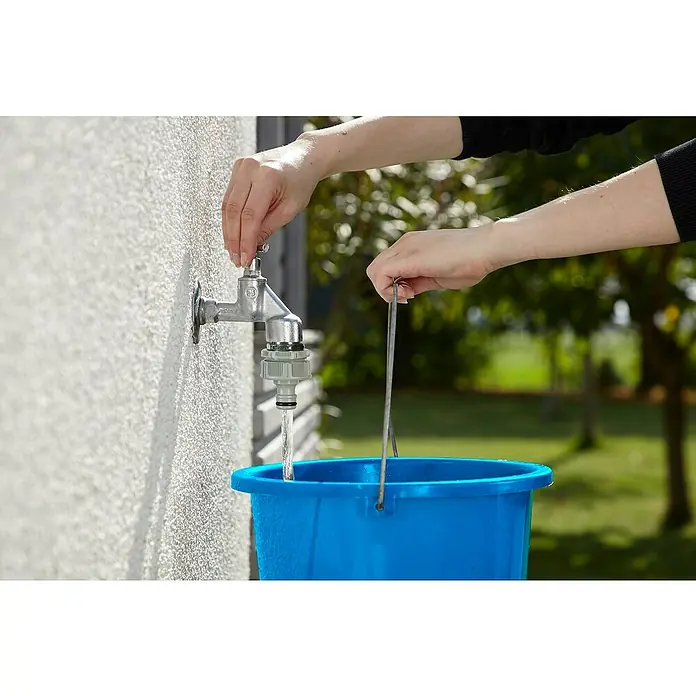 Gardena Adaptador para grifo - 33,3 mm (G 1) - Se está llenando un cubo azul con agua de un grifo Gardena. La persona está abriendo el grifo y sujetando el cubo.