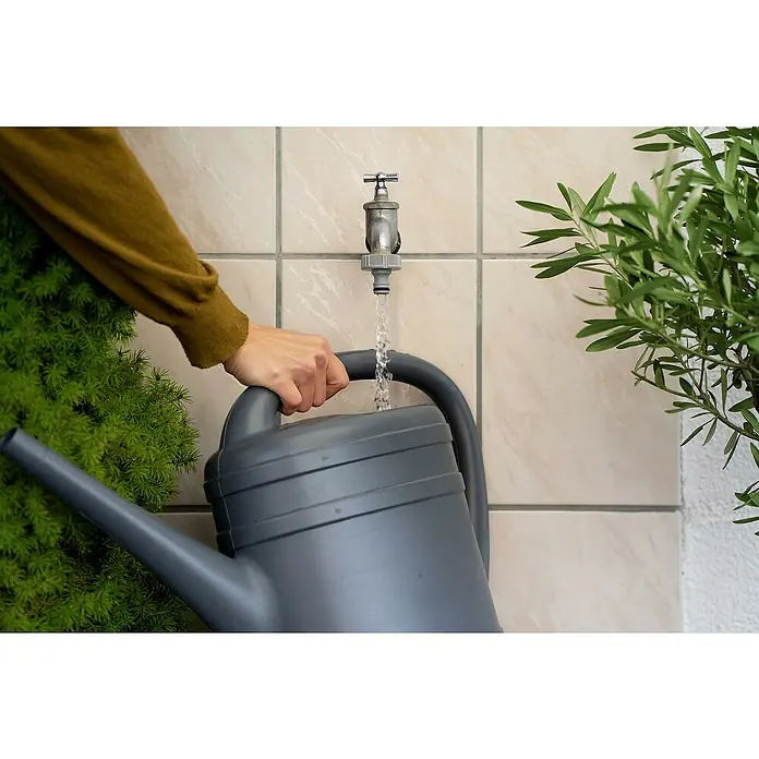 Gardena Adaptador para grifo - 33,3 mm (G 1) - Regadera llena de agua. Una regadera gris se está llenando debajo de un grifo, lista para regar plantas.