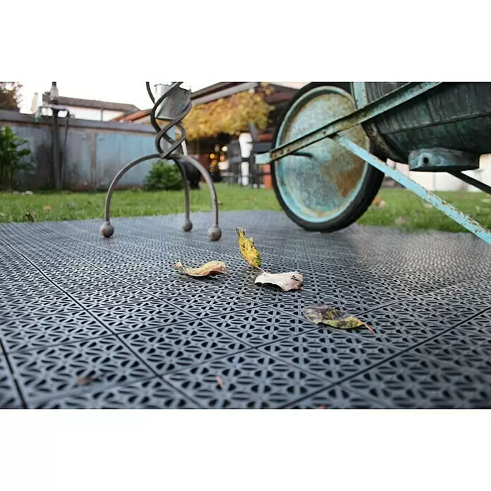 Klickfliese - Polyethylen, 55,5 x 55,5 x 1,1 cm, Mulitgrey, 1 Stk. - Dunkelgraue, ineinandergreifende Outdoor-Fliesen aus Kunststoff bedecken den Boden, mit Herbstblättern auf ihrer texturierten Oberfläche.