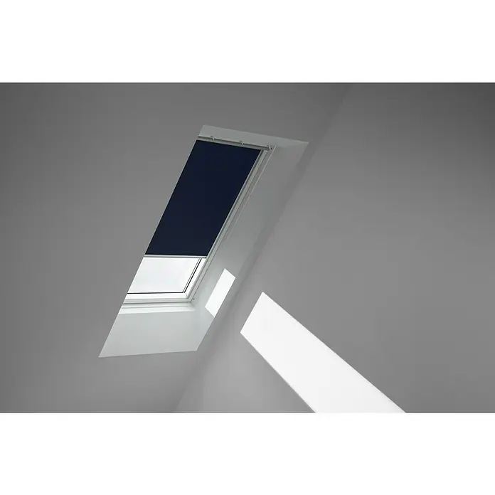 Velux Dachfensterrollo DKL FK04 1100S - Farbe: Dunkelblau - 1100S, Farbe Schiene: Aluminium, Manuell - Das Bild zeigt ein Dachfenster mit einem Rollo, das teilweise geschlossen ist und Licht ins Zimmer lässt. Das Fenster ist in einer schrägen Wand eingelassen.