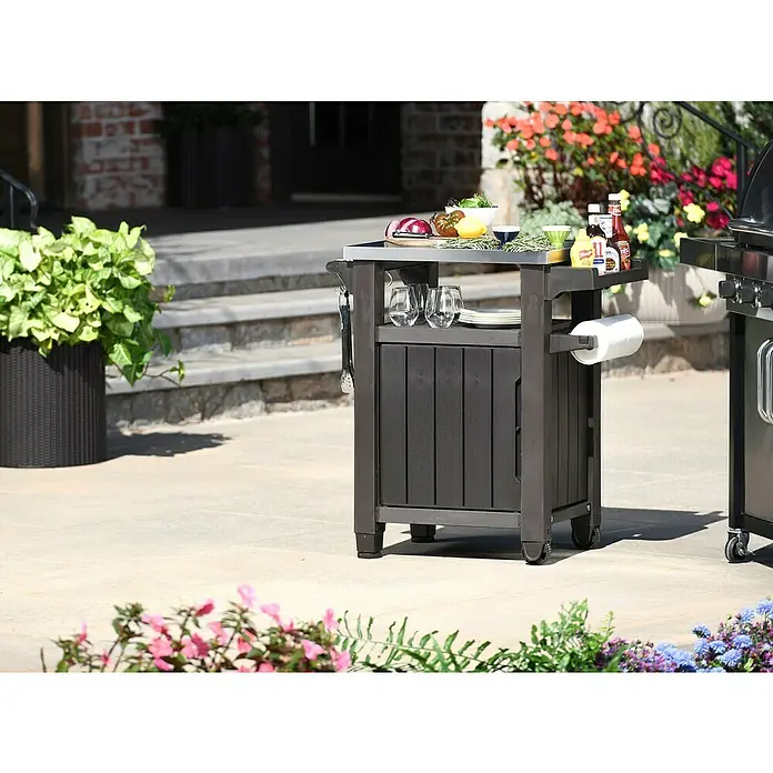 Keter Mesa auxiliar de jardín Unity - L x An: 82 x 52 cm, Marrón - Este elegante carrito de servicio para barbacoa cuenta con una tapa de acero inoxidable, almacenamiento y ruedas para una movilidad exterior sin esfuerzo.