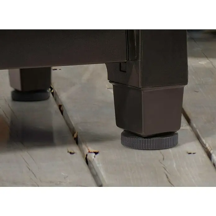 Keter Mesa de servicio Unity XL - 123,7 x 54 cm, Plástico, Marrón - Primer plano de una pata de mueble marrón con un pie ajustable sobre un suelo de madera, que proporciona estabilidad y nivelación.