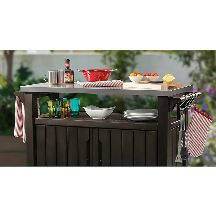 Keter Mesa de servicio Unity XL - 123,7 x 54 cm, Plástico, Marrón - Un primer plano de un carrito de cocina para exteriores con una tapa de acero inoxidable y varios accesorios de preparación de cocina.