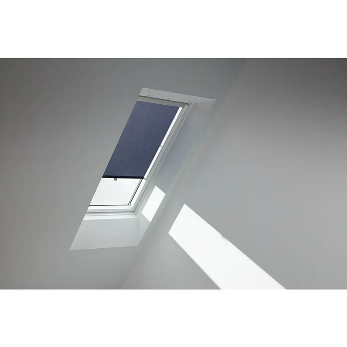 Velux Dachfensterrollo Haltekrallen RHL FK00 9050 - Farbe: Dunkelblau - 9050, Farbe Schiene: Aluminium, Manuell - Das Bild zeigt ein Dachfenster mit einem Rollo, das teilweise heruntergelassen ist. Das Fenster ist in eine weiße Decke eingebaut und wirft Licht auf die Wand.