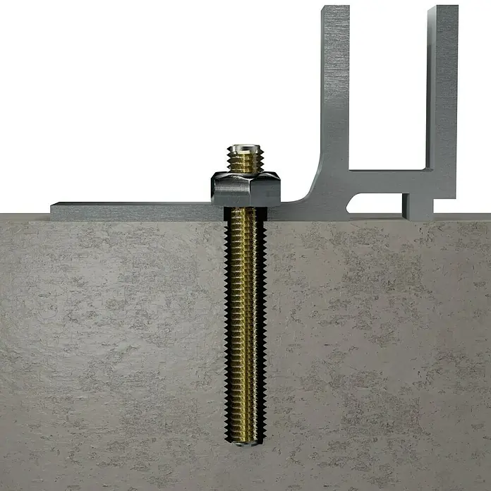 Suki Varilla roscada - M 3, 1 m, Latón - Primer plano de un perno y una tuerca que aseguran una pieza de metal a una losa de hormigón, destacando los elementos de fijación y los materiales de construcción.