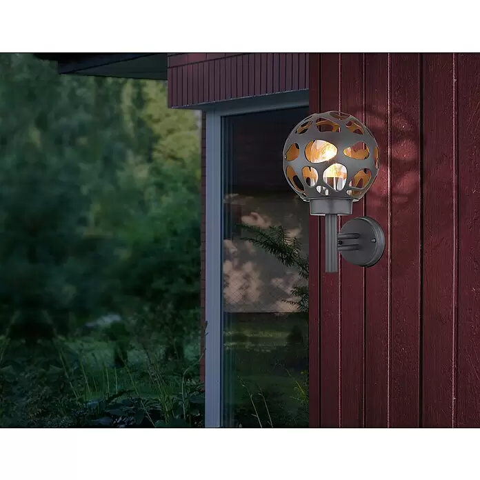 Globo Aplique exterior Hilario - 15 W, L x An x Al: 20 mm x 20 cm x 32,7 cm, Gris, IP44, Sin bombillas - Aplique de pared exterior esférico gris oscuro con interior dorado, proyectando patrones decorativos sobre una pared de madera rojiza.