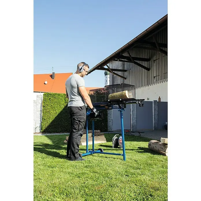Scheppach Holzspalter HL760LS - 2.200 W, 7 t, Max. Spaltgutlänge: 52 cm - 250 mm - Mann benutzt eine Scheppach Holzspalter Maschine im Freien, um Holz zu spalten, mit Kopfhörern und Handschuhen für Sicherheit.