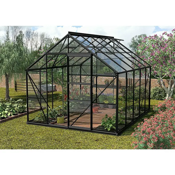 Vitavia Gewächshaus Merkur 8300 - Außenmaß inkl. Dachüberstand (B x T): 257 x 321 cm, 3 mm, Schwarz - Aufnahme eines Gewächshauses mit Pflanzen im Inneren und üppigem Grün im Garten. Das Gewächshaus bietet idealen Schutz für Pflanzen.