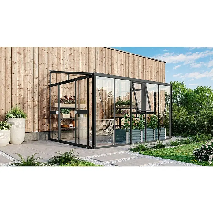 Vitavia Gewächshaus Helena 8600 - Außenmaß inkl. Dachüberstand (B x T): 334 x 266 cm, 3 mm, Schwarz - Ein modernes Gewächshaus mit schwarzem Rahmen, ausgestattet mit Pflanzenregalen und einer geöffneten Tür, umgeben von einer gepflegten Gartenanlage.