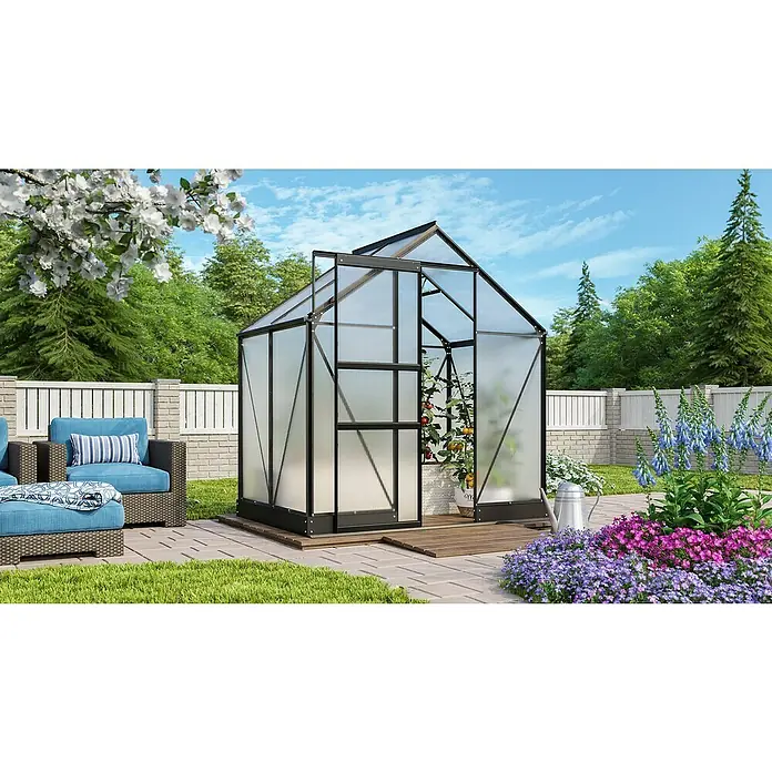 Vitavia Gewächshaus Apollo 2500 - Außenmaß inkl. Dachüberstand (B x T): 195 x 137 cm, 4 mm, Schwarz - Das Bild zeigt ein Gewächshaus im Garten, umgeben von Blumen und Pflanzen. Eine einladende Sitzecke lädt zum Verweilen ein.