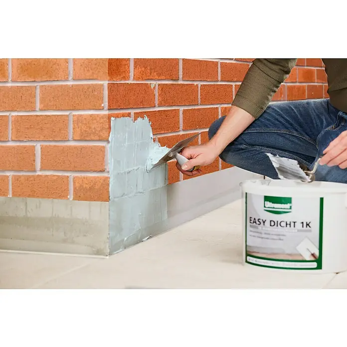 Ultrament Reaktivabdichtung Easy Dicht - 10 kg, 1-komponentig - Handwerker trägt Ultrament Easy Dicht 1K Abdichtmasse auf eine Ziegelwand auf.