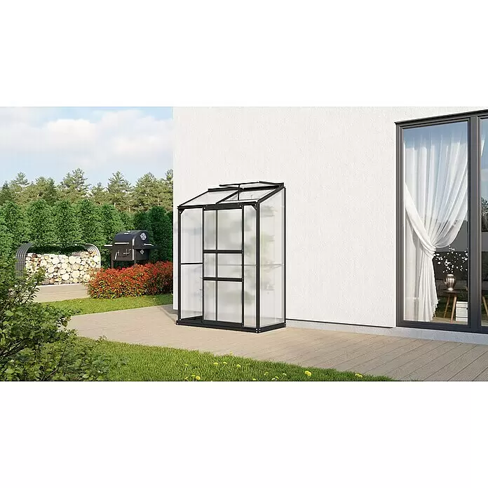 Vitavia Gewächshaus Styx 900 - Außenmaß inkl. Dachüberstand (B x T): 130,6 x 69 cm, 4 mm, Schwarz - Schwarz umrahmtes Gewächshaus mit Milchglasplatten an einem weißen Haus auf einer Holzterrasse im Garten.
