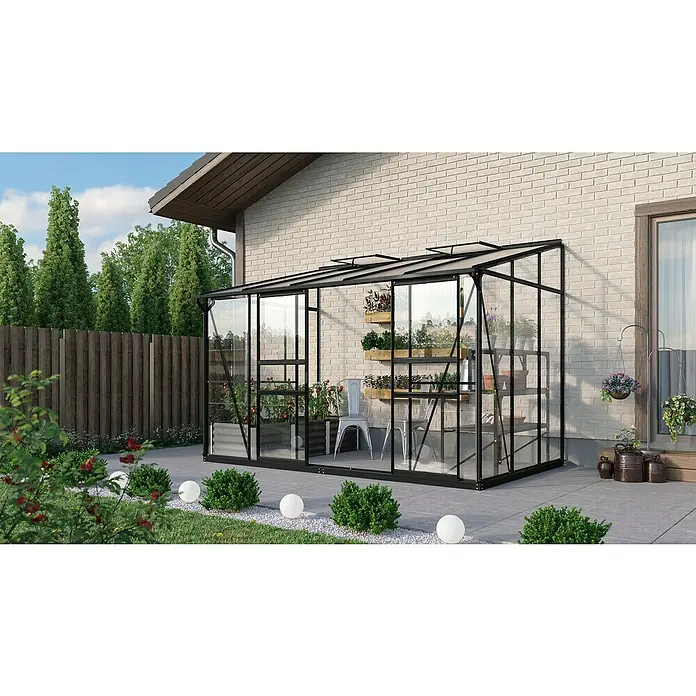 Vitavia Gewächshaus Osiris 6500 - Außenmaß inkl. Dachüberstand (B x T): 324,3 x 201 cm, 3 mm, Schwarz - Das Bild zeigt ein Gewächshaus mit Pflanzen und einer Leiter an einer Hauswand. Der Garten um das Gewächshaus ist wunderschön angelegt.