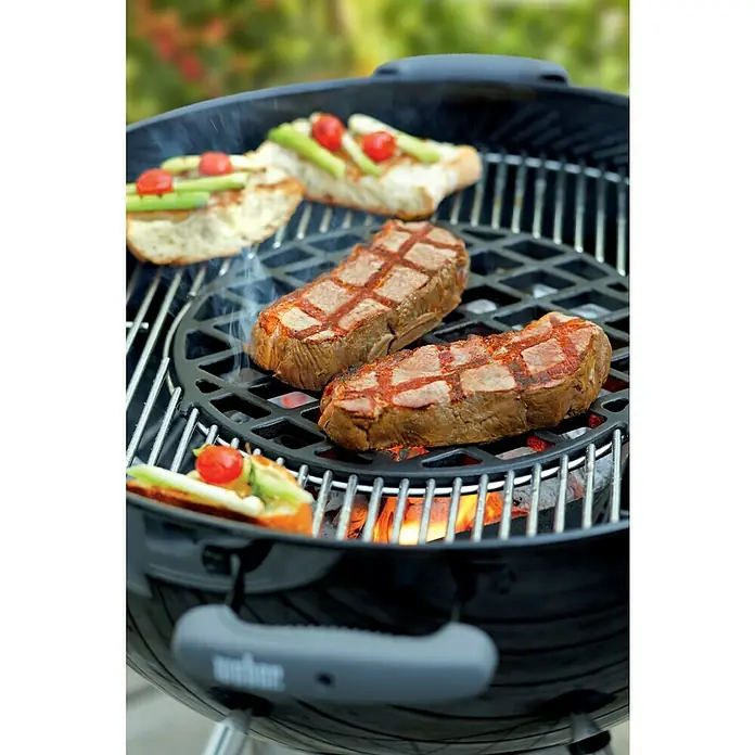 Weber Gourmet BBQ System Grillrost Sear Grate - L x B: 30 x 30 cm, Durchmesser: 30 cm, Gusseisen - Nahaufnahme eines Weber Grills mit saftigen Steaks und leckeren Bruschetta, die auf dem Grill zubereitet werden. Genuss pur beim Grillen!