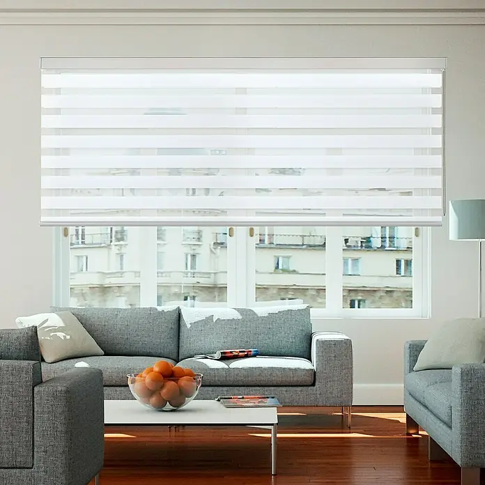 Estor noche y día Platinum Square - An x Al: 80 x 250 cm, Blanco - Primer plano de persianas enrollables blancas que cubren una ventana en una sala de estar moderna, ofreciendo privacidad con un toque de elegancia.