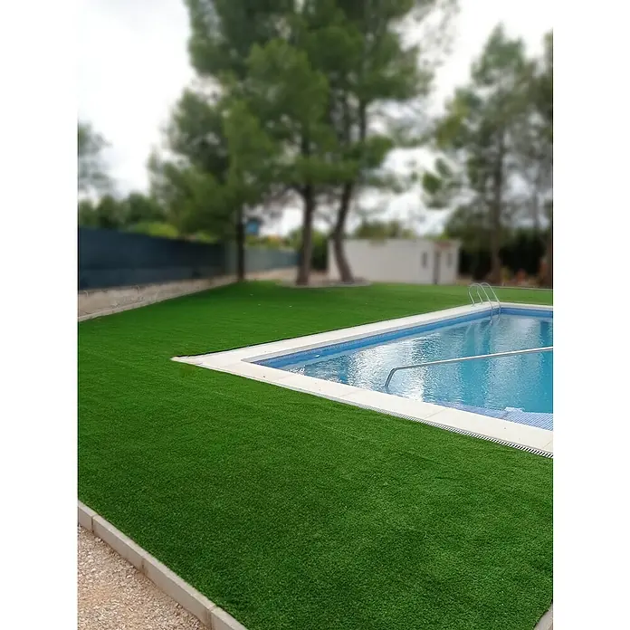 Césped artificial Malta - 5 x 2 m, Altura del pelo: 30 mm, 1.350 puntadas/m² - Esta imagen muestra una piscina rodeada de césped artificial. Es un espacio exterior hermoso y relajante para disfrutar del tiempo libre.