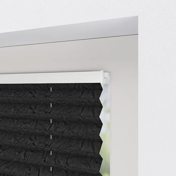 Expo Ambiente Plissee - B x H: 70 x 130 cm, Dunkelgrau - Nahaufnahme einer schwarzen Plissee-Jalousie, die an einem Fensterrahmen befestigt ist und für Privatsphäre und Abdunkelung sorgt.