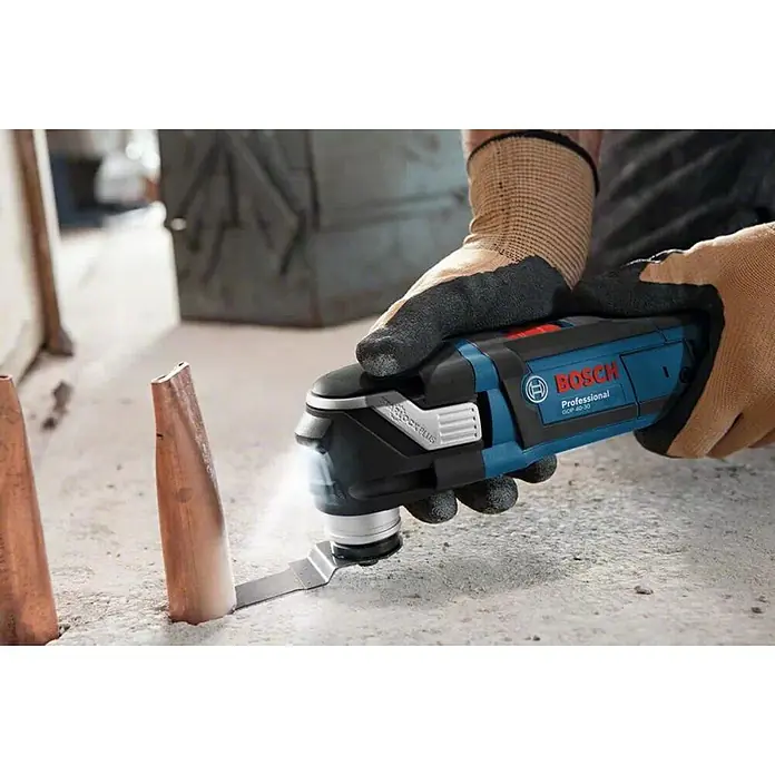 Bosch Professional Multiherramienta GOP 40-30 + accesorios - 400 W, Sistema STARLOCK - Primer plano de una multiherramienta Bosch GOP 40-30 cortando un tubo de cobre. Herramienta profesional para aplicaciones versátiles.