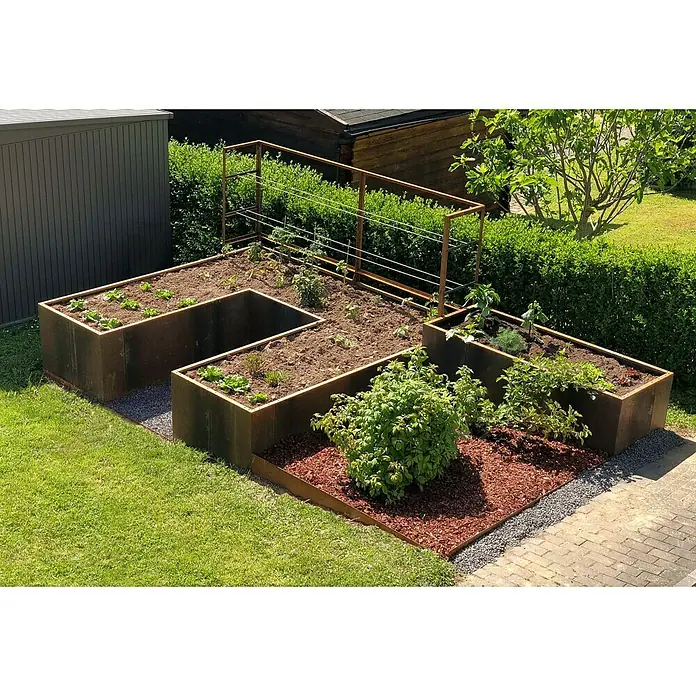 Palatino Hochbeet Urban U-Form - 300 x 200 x 70 cm, Stahl, Rostbraun - Erhöhter Garten mit Gemüsebeeten aus Metall, umgeben von Rasen und roten Mulch. Gemüse wächst in den Beeten unter einer Pflanzenstützstruktur.