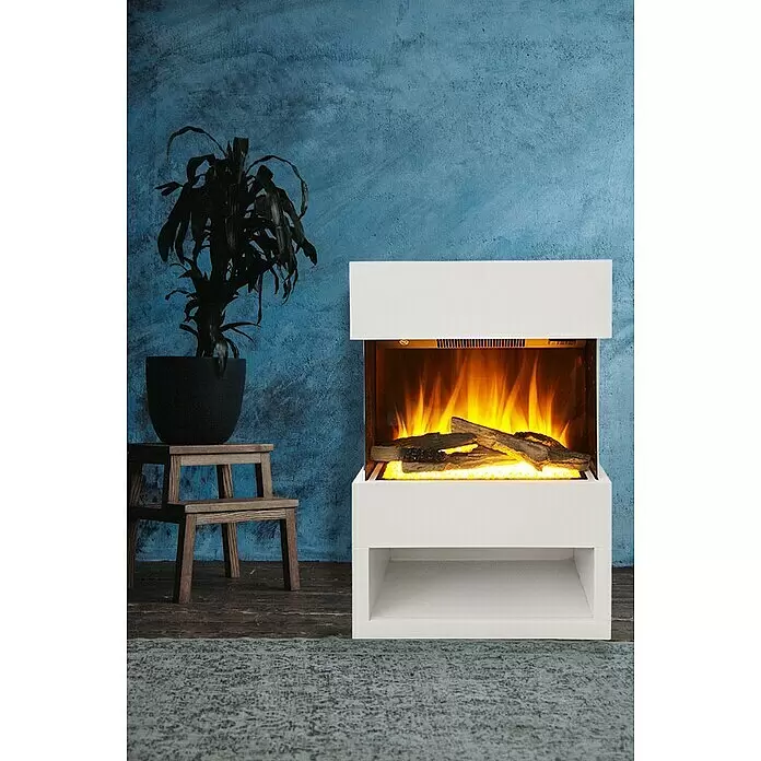 Voltomat HEATING Elektrischer Kamin Malmö - 1.500 W, Weiß, 25,1 x 55,6 x 76 cm - Weißer Elektrokamin mit realistischen Flammen und Holzscheiten, in einem modernen Raum mit blauer Wand und Pflanze.