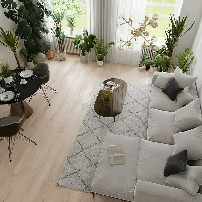 Parkett - Eiche Antique Davos, Landhausdiele, 1.900 x 190 x 15 mm - Innenansicht eines Wohnzimmers mit einer grauen Couch, einem Couchtisch, einem Esstisch und vielen Pflanzen, die eine warme und einladende Atmosphäre schaffen.