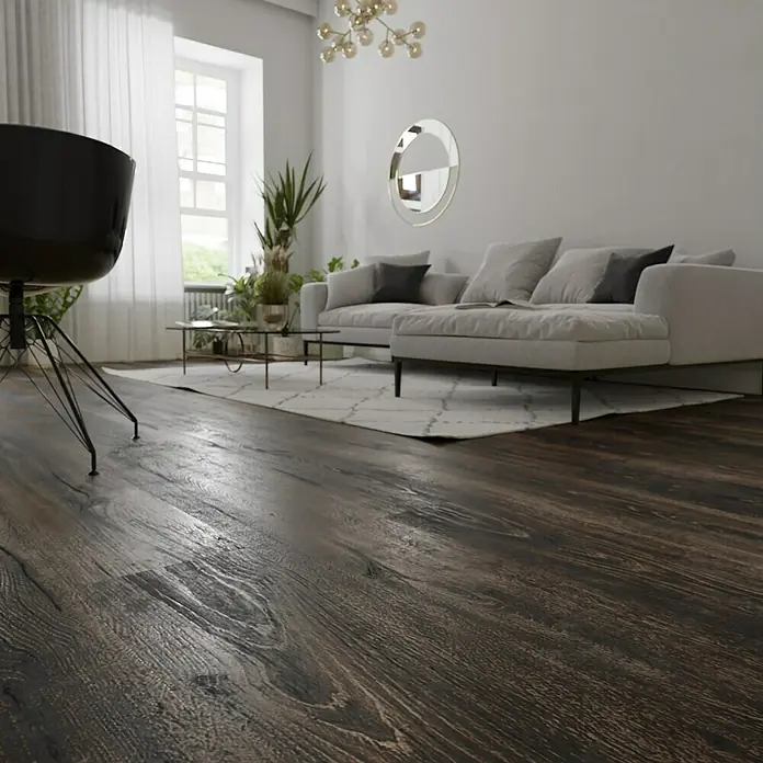 Parkett - Eiche Grindelwald, Landhausdiele, 1.900 x 190 x 15 mm - Nahaufnahme eines dunklen, strukturierten Holzfußbodens in einem hellen Wohnzimmer, der die natürliche Maserung und Wärme des Materials hervorhebt.