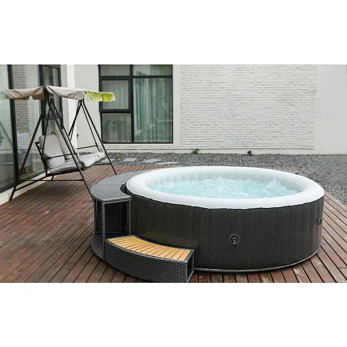 MSpa Hidromasaje móvil Treviso - Ø x Al: 204 x 70 cm, Gris, 930 l - Jacuzzi inflable redondo con borde de ratán gris y escalones de madera en una terraza de madera. Disfrute de horas de relax al aire libre.