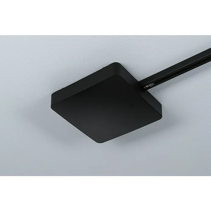 Paulmann URail Mittel-Einspeisung Zigbee - 300 W, Schwarz - Nahaufnahme einer schwarzen Deckenleuchte, die an einer Schiene befestigt ist, vor einem hellgrauen Hintergrund.