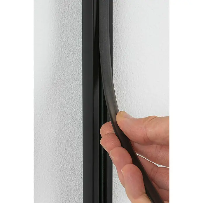 Paulmann URail Abdeckung - Länge: 68 cm, Schwarz matt - Nahaufnahme einer Hand, die eine schwarze Dichtung in einen schwarzen Rahmen einsetzt.