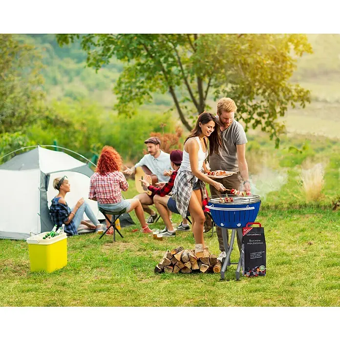 LotusGrill Barbacoa de carbón - Diámetro de la superficie de la parrilla: 34 cm, Rojo fuego - Un grupo de amigos acampando y asando a la parrilla con una parrilla de carbón LotusGrill y disfrutando del aire libre.