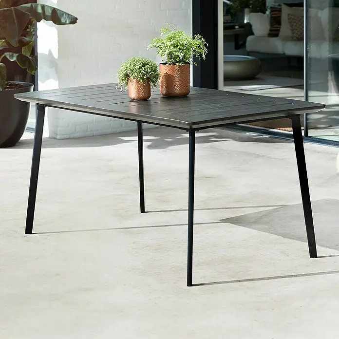 Keter Mesa de jardín Metalea - L x An x Al: 146,5 x 87 x 75 cm, Polipropileno, Marrón - Mesa de comedor gris con estructura metálica negra y dos pequeñas plantas en macetas, ideal para uso exterior en jardín o terraza.