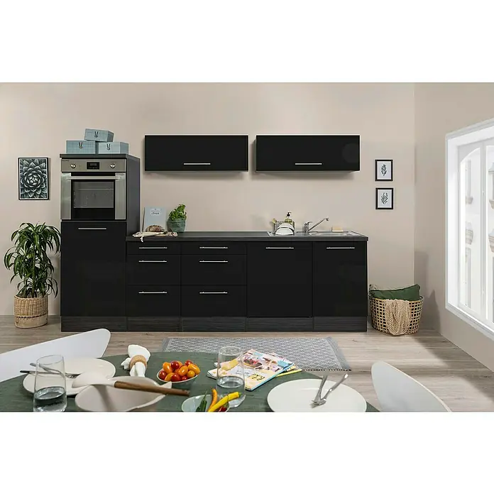 Respekta Premium Cocina de isla Amanda - Ancho: 280 cm, Roble/Negro, Con electrodomésticos - Vista de cocina con armarios bajos negros, armarios altos y mesa de comedor en primer plano. Esta moderna cocina ofrece mucho espacio de almacenamiento.