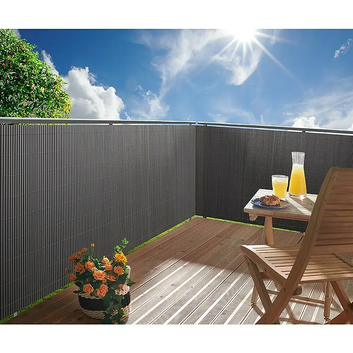 Gardol Comfort Sichtschutzmatte - Anthrazit, 300 x 90 cm - Eine graue Sichtschutzwand aus Bambus auf einem Balkon mit Tisch, Stuhl, Getränken und Blumen für Privatsphäre und Gemütlichkeit.
