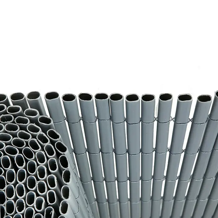 Gardol Comfort Sichtschutzmatte - Silber, 300 x 90 cm - Eine Nahaufnahme eines grauen Sichtschutzzauns aus ovalen Röhren, zusammengehalten durch Draht, neben einem Stapel loser Röhren.