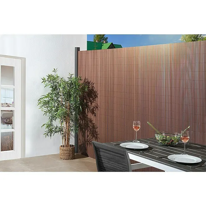 Gardol Comfort Sichtschutzmatte - Braun, 300 x 180 cm - Der braune Sichtschutzzaun bietet Privatsphäre und dient als stilvolle Kulisse für den Essbereich im Freien mit Tisch, Stuhl und Dekoration.