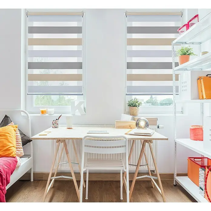 Estor enrollable Clip&Fix Tricolor - An x Al: 90 x 180 cm, Tricolor - Habitación con estores enrollables: La imagen muestra una habitación luminosa con modernos estores enrollables a rayas en tonos gris, beige y blanco.
