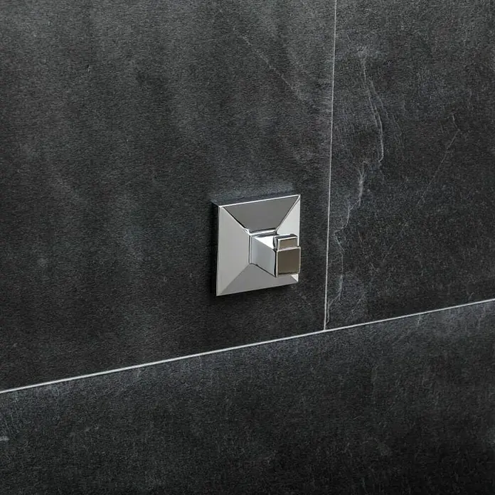 Tatay Iconik Colgador - Número de ganchos: 1 ud. - Primer plano de una válvula termostática cuadrada brillante con manija sobre una pared oscura y texturizada.